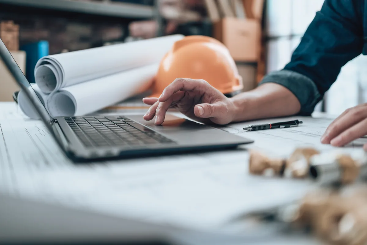 Architect working over blueprints and drawings at a studio worktable