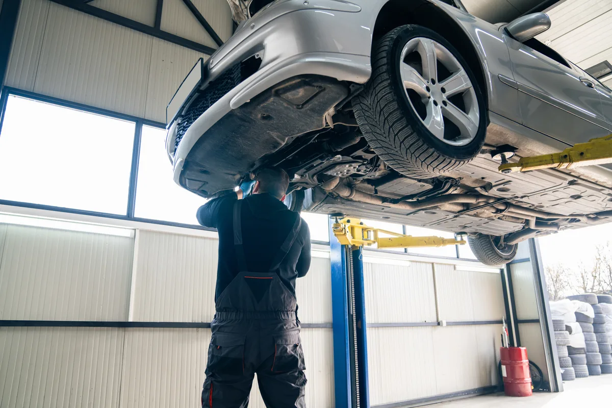Mechanic working on a vehicle hoist in an independent repair shop