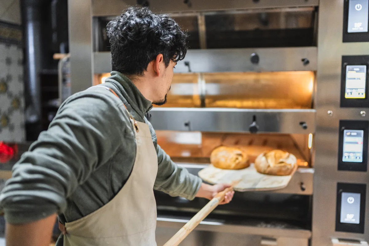Baker icing a custom cake in a bakery kitchen