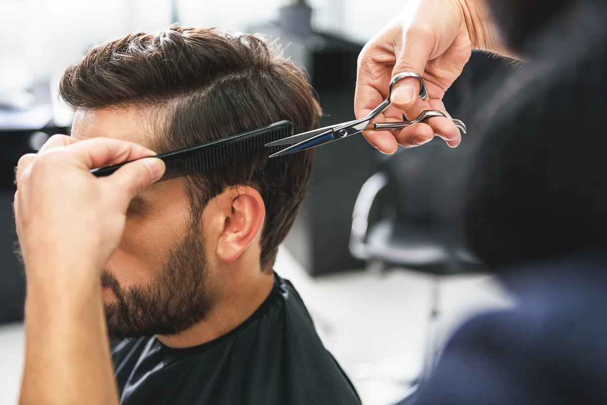 Barber cutting a client's hair at the chair in a barbershop