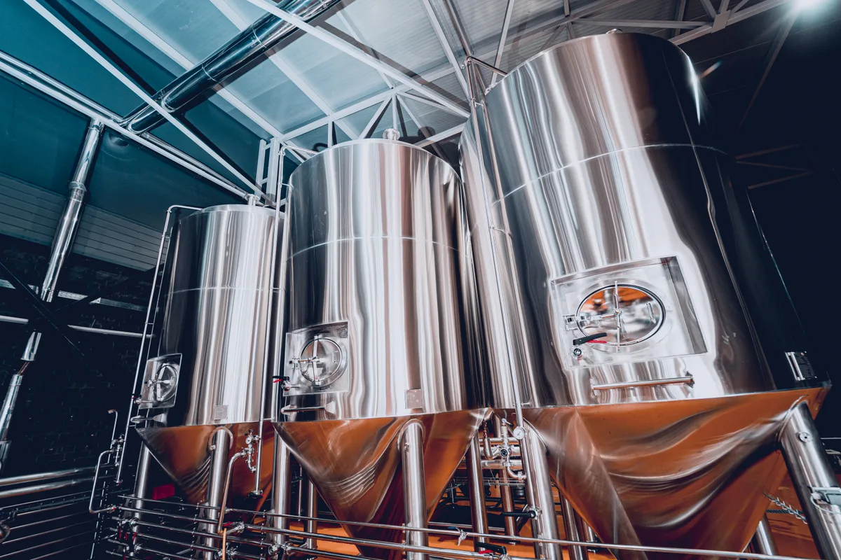 Stainless steel fermentation tanks inside a craft brewery