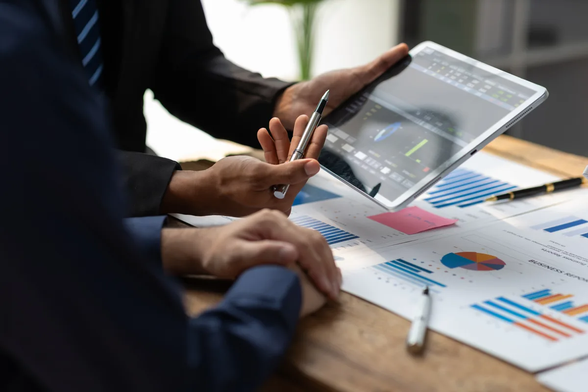 Charts showing investment gains on a desk beside a corporate tax file