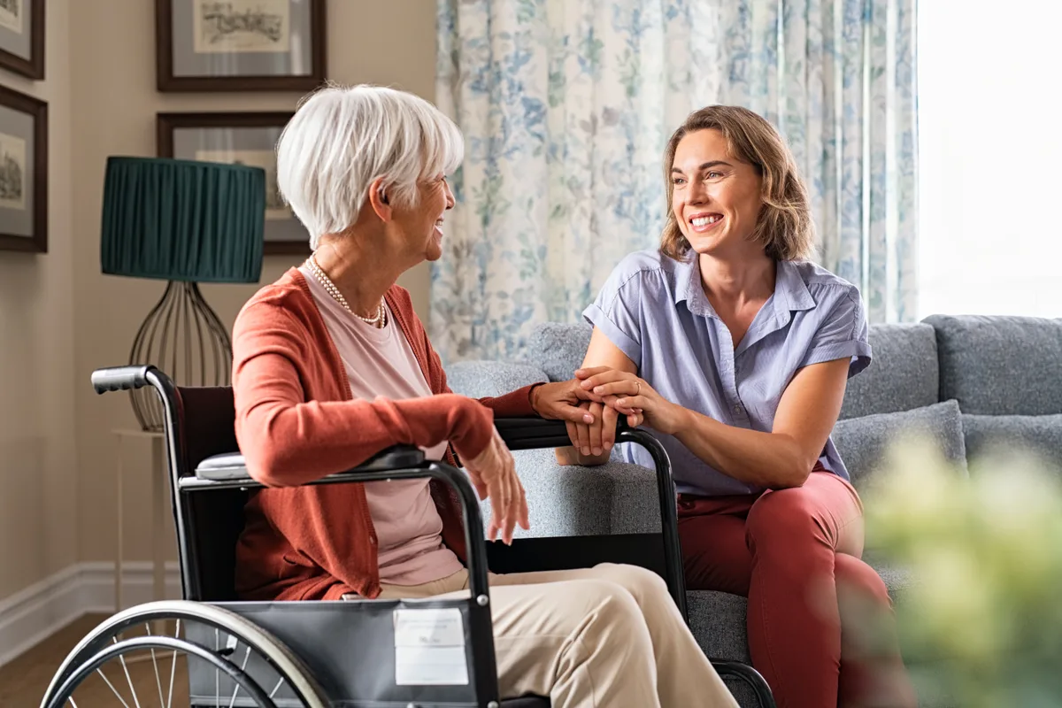 Caregiver helping a senior client at home during a scheduled visit
