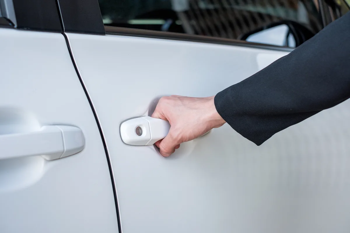 Chauffeur company owner reviewing fleet numbers beside a parked car