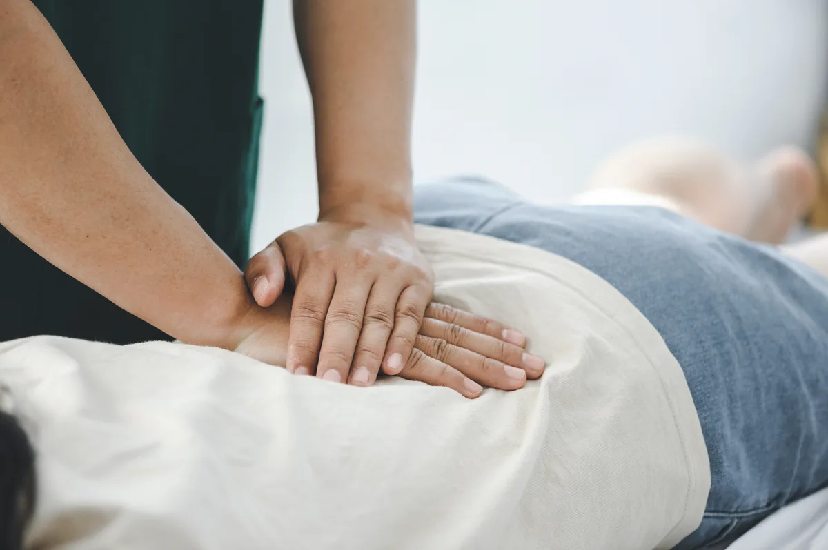 Chiropractor performing a spinal adjustment on a patient