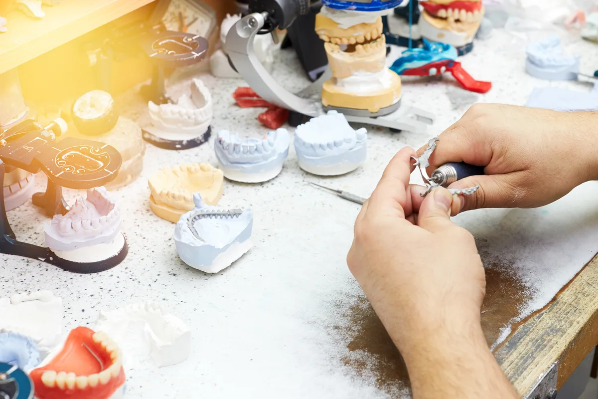 Dental lab technician reviewing cases in a production lab