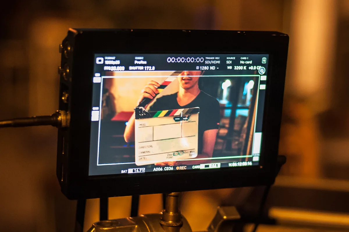 Film crew member holding a clapperboard on set during production