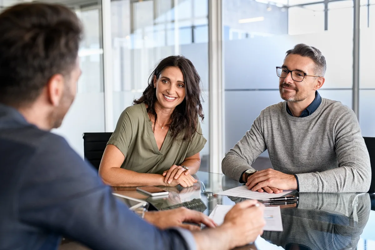 Financial advisor meeting with clients across a desk