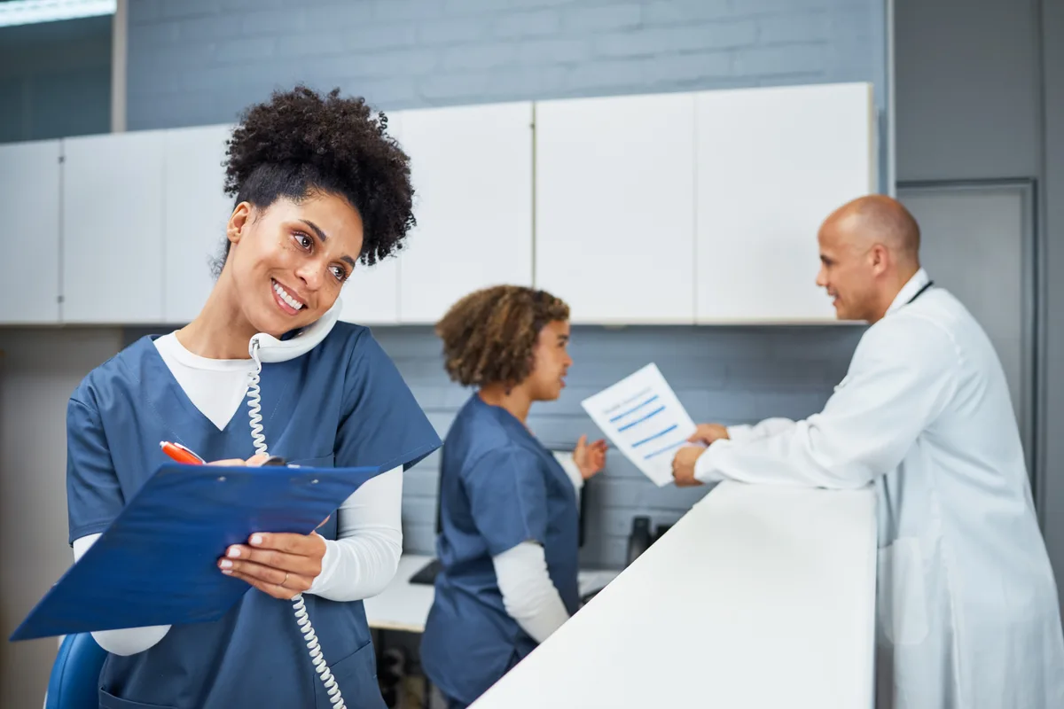 Medical team reviewing documents at a clinic front desk