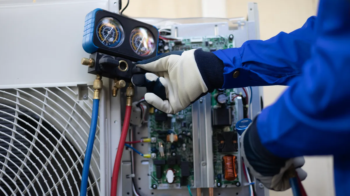 HVAC technician servicing a residential air-conditioning unit