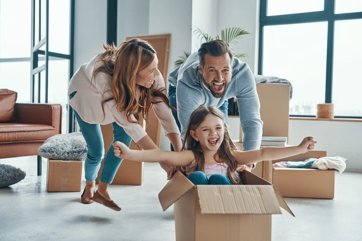 Packed moving boxes and a passport on a kitchen counter beside a folder of Canadian tax documents