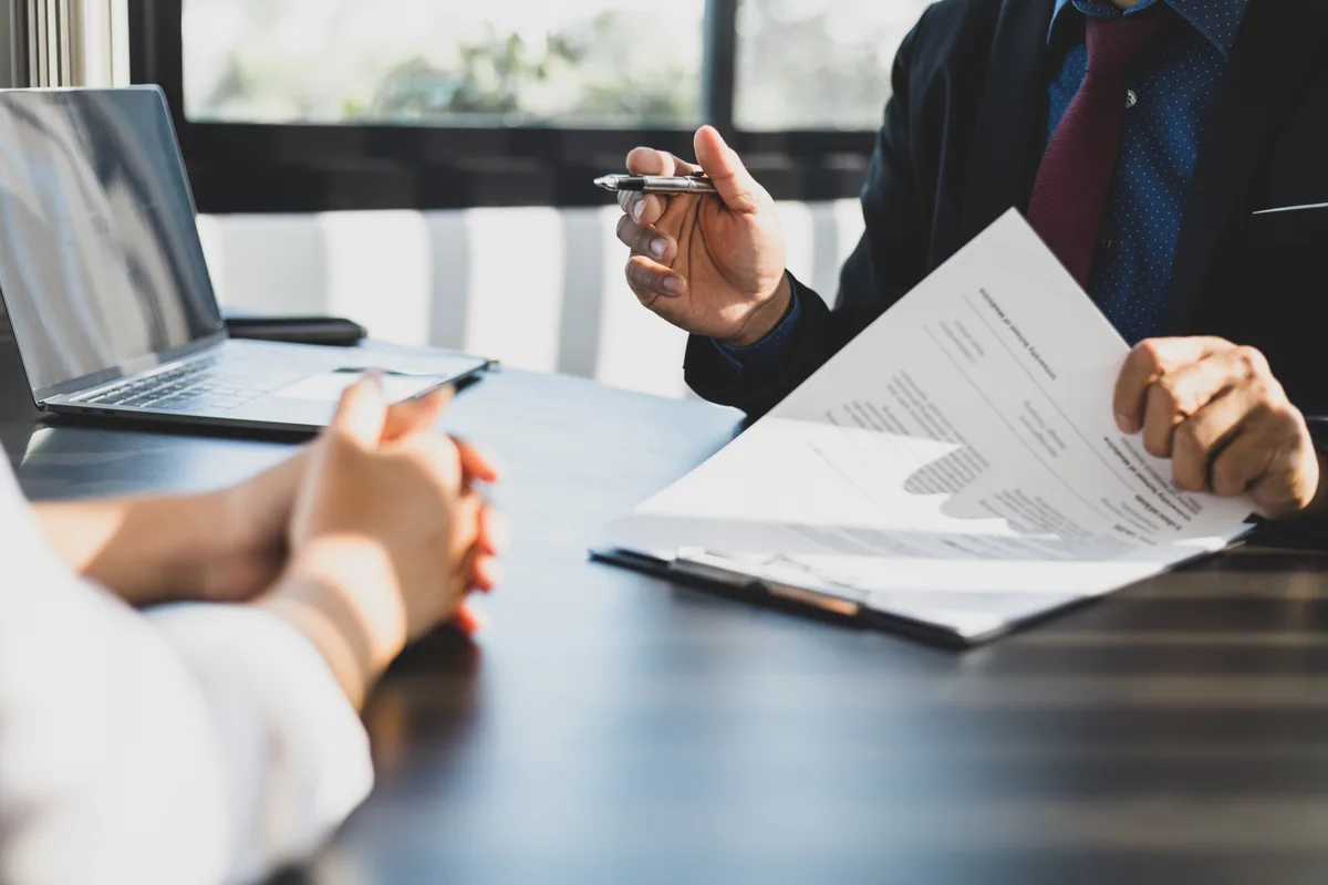 Mortgage broker reviewing signing documents with clients