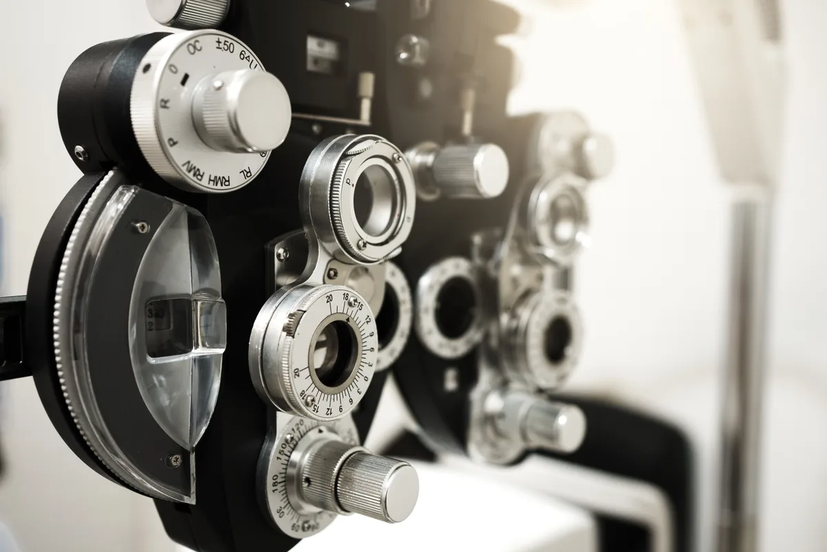 Optometrist positioning a phoropter during an eye exam