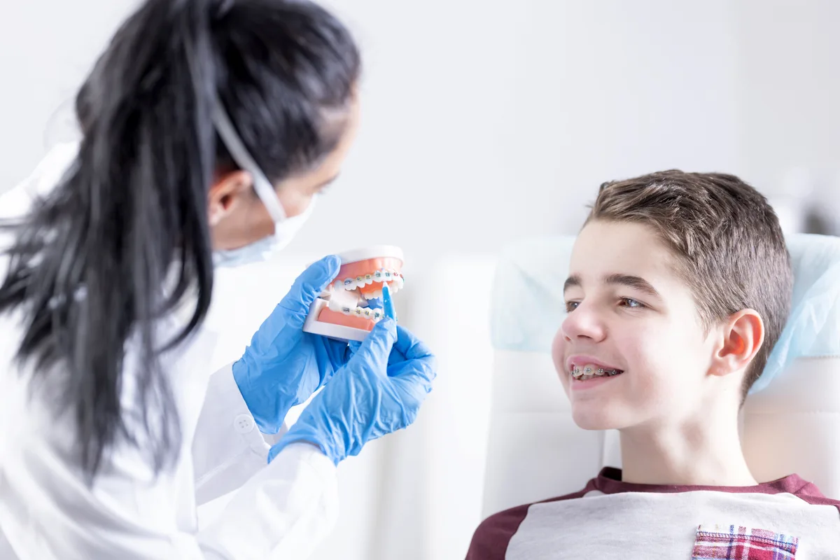 Orthodontist adjusting braces for a patient in a treatment chair