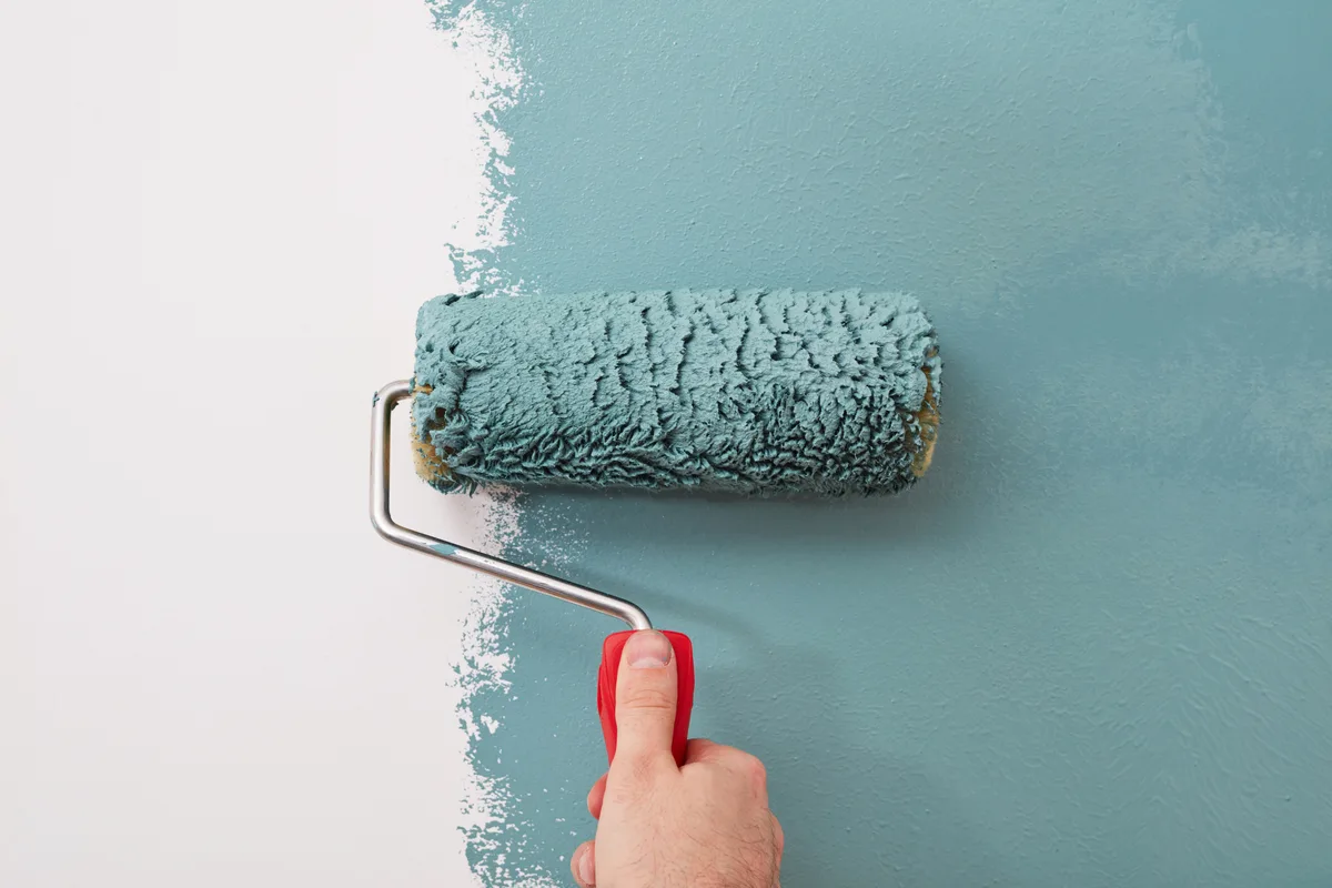 Painter rolling fresh paint onto an interior wall