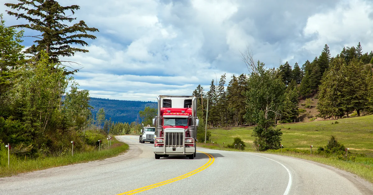 Semi truck pulling a trailer down a Canadian highway