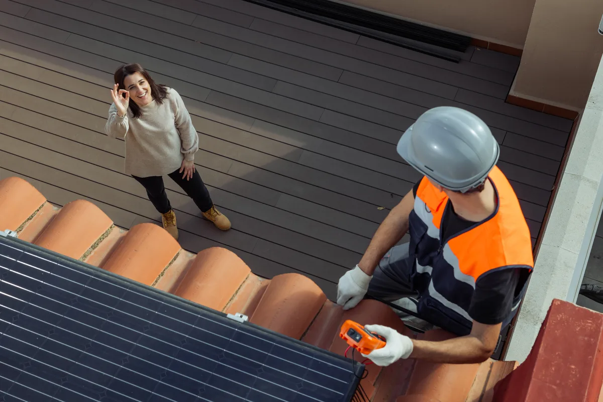 Solar installer reviewing job costs on a tablet at a work site
