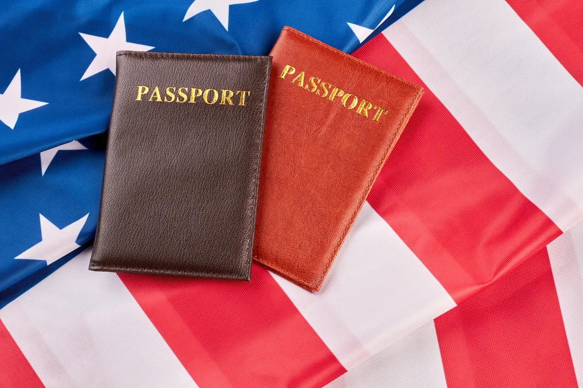Canadian and US passports on a desk beside tax paperwork