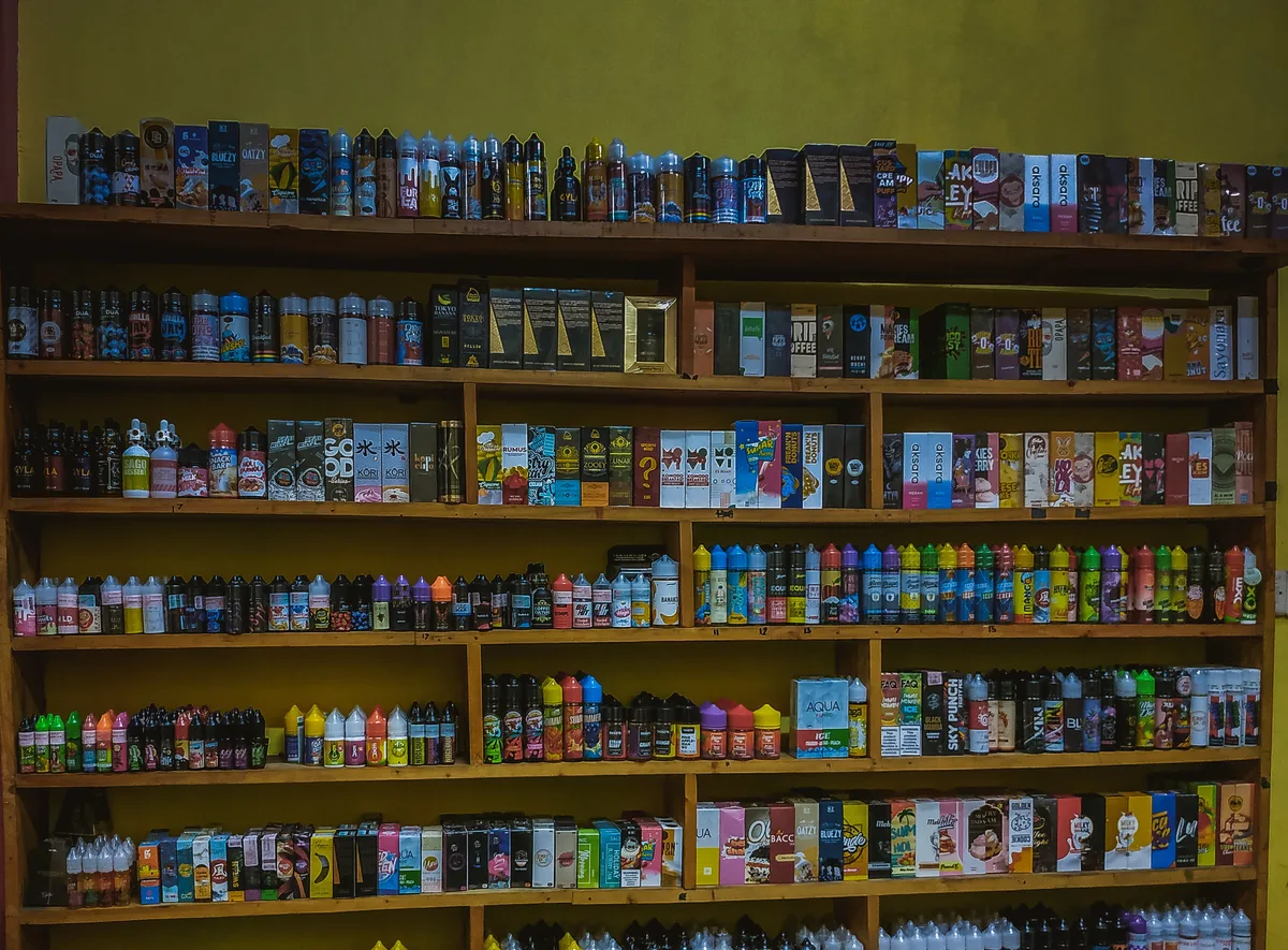 Vape shop owner reviewing sales reports behind the counter